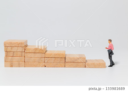 Businessman Climbing Wooden Steps Toward Success Businessman Climbing Wooden Steps Toward Success 133981689
