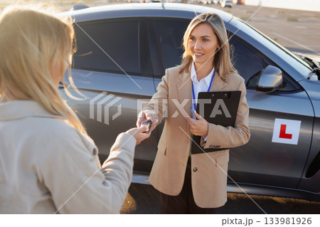 Driving Teacher Handing Over Car Keys to Student Before Lesson 133981926