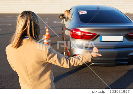 Driving Instructor Signaling During Reverse Parking Exercise 133981997