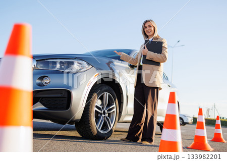 Instructor Presenting Training Car for Driving Lesson 133982201