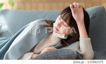 体調不良でソファで横になる女性 体調不良でソファで横になる女性 133982375