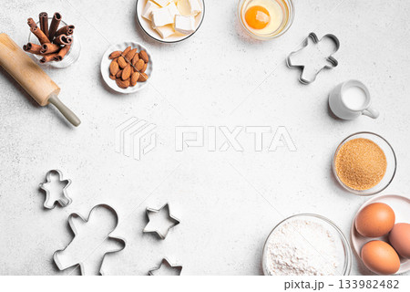 Christmas baking background with baking ingredients and cookie cutters Christmas baking background with baking ingredients and cookie cutters 133982482