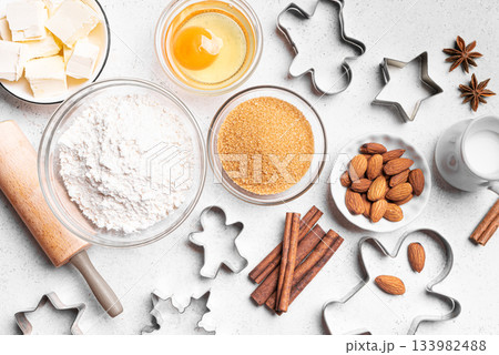 Christmas baking background with baking ingredients and cookie cutters Christmas baking background with baking ingredients and cookie cutters 133982488