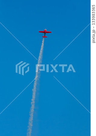 Stunt aerobatic plane performing stunts in air 133983365