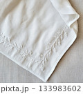 Clean white linen fabric with embroidery. Minimalist background napkin for product mockups. 133983602