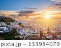 Breathtaking sunset over Lisbon, highlighting the city's rooftops, Carmo Convent ruins, and the iconic 25th of April Bridge. Portugal 133984079