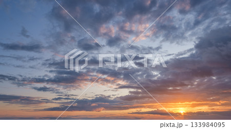 At sunset vibrant colors fill the sky, creating a stunning backdrop with dramatic clouds, perfect for relaxation and reflection. 133984095