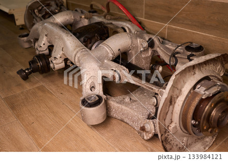 Vintage vehicle restoration, Old car parts under warm workshop lighting, Scene depicting classic vehicle undergoing restoration with rusted parts and scattered tools 133984121
