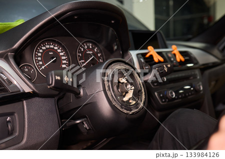 Detailed car repair, Focused shot of hands restoring vehicle steering component carefully, Precision work on vehicle steering wheel with tools in gritty garage environment Detailed car repair, Focused shot of hands restoring vehicle steering component carefully, Precision work on vehicle steering wheel with tools in gritty garage environment 133984126