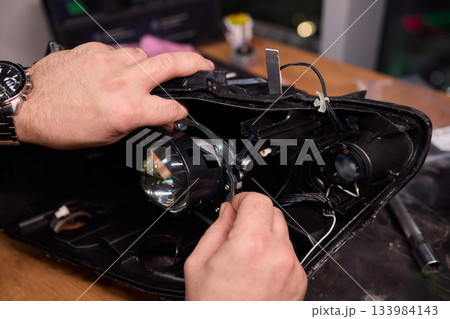 Careful precision is essential when installing a car headlight assembly for optimal performance 133984143