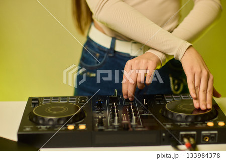 DJ setup overview, Energetic club DJ performing with digital controller in action, Content creator mixing music live using digital turntables under vibrant stage lights DJ setup overview, Energetic club DJ performing with digital controller in action, Content creator mixing music live using digital turntables under vibrant stage lights 133984378