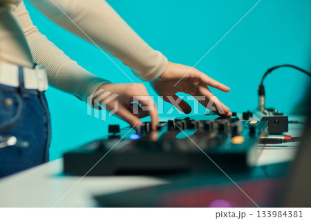 DJ setup overview, Energetic club DJ performing with digital controller in action, Content creator mixing music live using digital turntables under vibrant stage lights DJ setup overview, Energetic club DJ performing with digital controller in action, Content creator mixing music live using digital turntables under vibrant stage lights 133984381