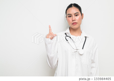 Woman Doctor with Stethoscope in White Uniform on Plain Background Pointing Finger Woman Doctor with Stethoscope in White Uniform on Plain Background Pointing Finger 133984405