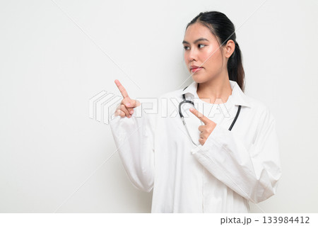 Woman Doctor with Stethoscope in White Uniform on Plain Background Pointing Finger 133984412