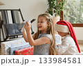A boy in a santa hat and girl unpacking the christmas presents 133984581