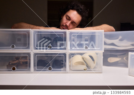 Organizing clear shoe containers effectively, Arranging transparent footwear storage with focus and style, Meticulous placement of feedthrough shoe boxes in minimalist 133984593