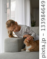 A girl near a ginger cat on the couch 133984649