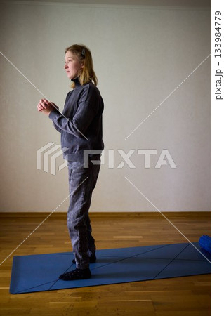 Woman exercises indoors, Individual with cerebral palsy performing warmup, Serene young woman with mobility challenges practicing controlled physiotherapy routines indoors 133984779