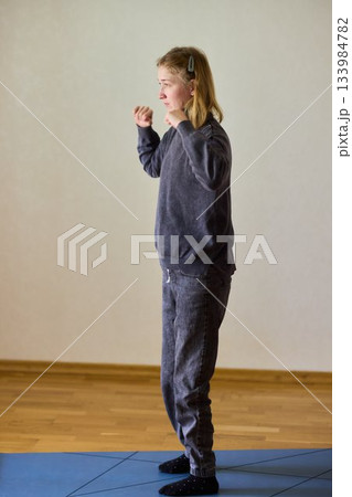 Woman exercises indoors, Individual with cerebral palsy performing warmup, Serene young woman with mobility challenges practicing controlled physiotherapy routines indoors 133984782