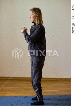 Woman exercises indoors, Individual with cerebral palsy performing warmup, Serene young woman with mobility challenges practicing controlled physiotherapy routines indoors Woman exercises indoors, Individual with cerebral palsy performing warmup, Serene young woman with mobility challenges practicing controlled physiotherapy routines indoors 133984783