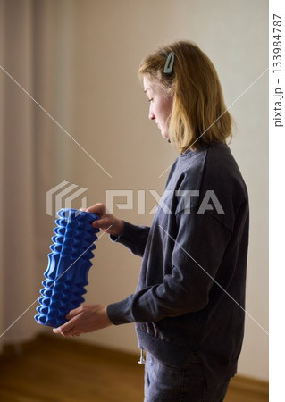 Woman exercises indoors, Individual with cerebral palsy performing warmup, Serene young woman with mobility challenges practicing controlled physiotherapy routines indoors 133984787