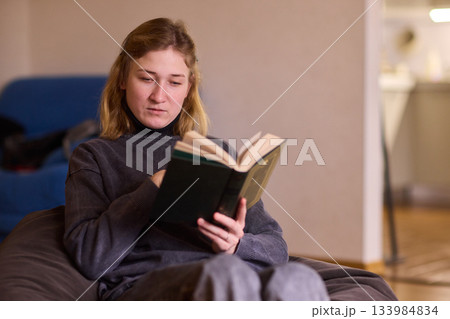 Determined individual with cerebral palsy immersed in educational activities indoors, Courageous woman with cerebral palsy concentrates on studying at home with dedication Determined individual with cerebral palsy immersed in educational activities indoors, Courageous woman with cerebral palsy concentrates on studying at home with dedication 133984834