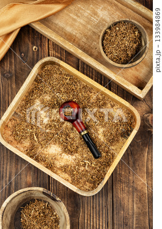 Tobacco pipe on rustic wooden table. Tobacco pipe on rustic wooden table. 133984869