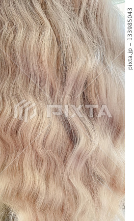 Full frame close-up of healthy, shiny blonde wavy hair texture. Ideal for beauty background 133985043
