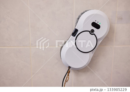 Smart robot performing quick hygienic maintenance in bathroom space, Modern robotic cleaner diligently scrubbing grout lines adjacent to toilet in bright tiled room Smart robot performing quick hygienic maintenance in bathroom space, Modern robotic cleaner diligently scrubbing grout lines adjacent to toilet in bright tiled room 133985229