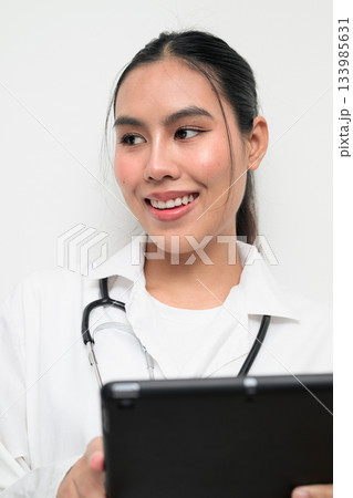Asian Woman Doctor in White Uniform Using Digital Tablet Computer on Plain White Background Thinking 133985631
