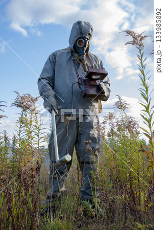 Military dosimetrist measures radiation, ACRID SMOKE after the EXPLOSION, chemical protective suit and gas mask, Military dosimetrist measures radiation, ACRID SMOKE after the EXPLOSION, chemical protective suit and gas mask, 133985892
