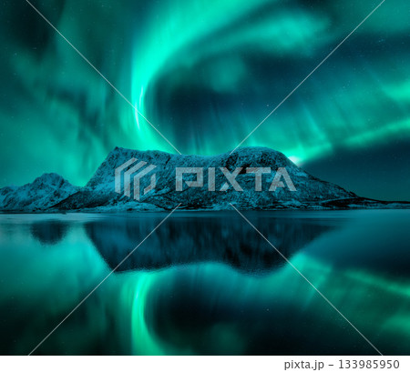 Aurora borealis over the snowy mountains, reflection in water Aurora borealis over the snowy mountains, reflection in water 133985950