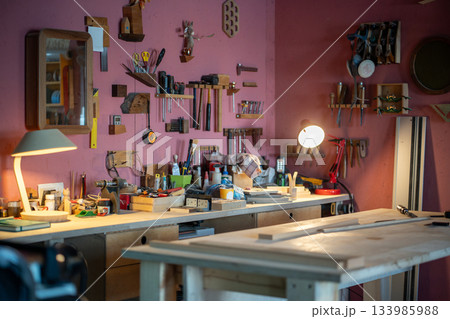 Cozy carpentry workshop interior workplace with tools, equipment and materials on wooden table. 133985988