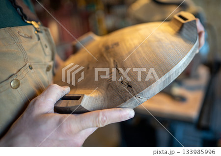 Carpenter checking material quality issues, business owner producing unique solid wood furniture. Carpenter checking material quality issues, business owner producing unique solid wood furniture. 133985996