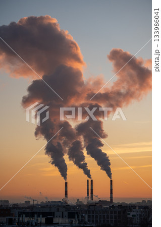 Smoke from factory pipe of heat station in city in winter. Fuel oil or natural gas-fired power plant 133986041
