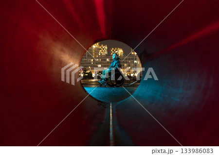 Young disabled man in rgb color light sits in wheelchair looking at city lights, thinking about life Young disabled man in rgb color light sits in wheelchair looking at city lights, thinking about life 133986083