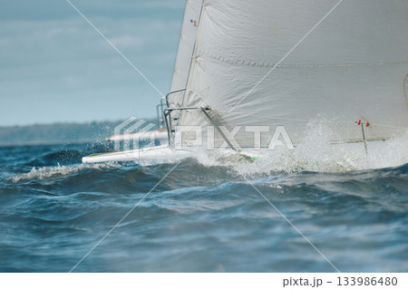 bow of a sailing boat with bowsprit at sailing regatta in the Gulf of Finland at sunny day, sailing yacht competing in a race, splashing water from under the boat, teamwork, board the boat 133986480