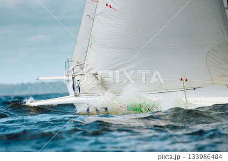 bow of a sailing boat with bowsprit at sailing regatta in the Gulf of Finland at sunny day, sailing yacht competing in a race, splashing water from under the boat, teamwork, board the boat 133986484