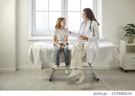 Doctor Or Nurse Consulting Boy Patient In Hospital Office 133986828