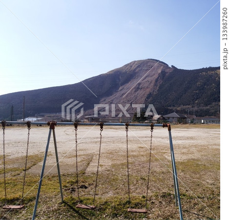 大規模山腹崩壊（数鹿流崩れなど）を望む廃校の校庭のブランコ 133987260