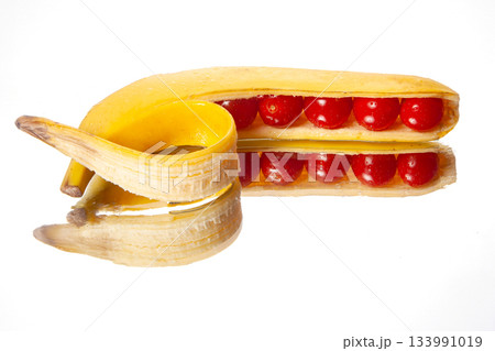 A peeled banana creatively sliced to reveal cherry tomatoes inside A peeled banana creatively sliced to reveal cherry tomatoes inside 133991019
