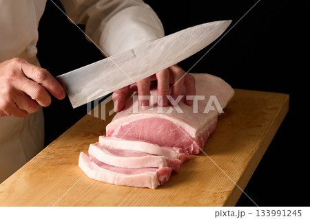 豚ロースをカットする料理人 133991245