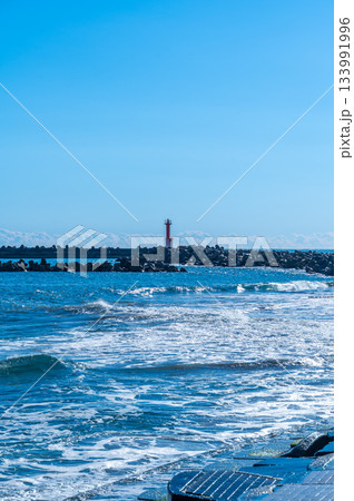 海岸に立つ赤い灯台と白波が広がる美しい海の風 海岸に立つ赤い灯台と白波が広がる美しい海の風 133991996