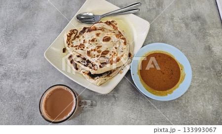 This is a group of food with Roti Canai, Teh Tarik and Curry This is a group of food with Roti Canai, Teh Tarik and Curry 133993067