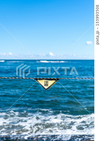 海を背景にした注意標識のクローズアップ 海を背景にした注意標識のクローズアップ 133993508