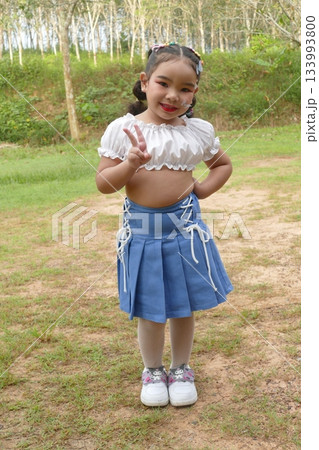 Portrait of little girl in a blue dress in the park 133993800