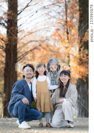 秋の家族写真・紅葉の森で笑顔の三世代家族ポートレート・親子と祖母の記念撮影　カメラ目線思い出 133993878