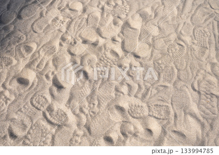 人々が歩いた痕跡が残る砂浜の足跡模様 133994785