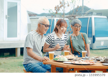 海辺で親子三人が立ち乾杯するシーン 海辺で親子三人が立ち乾杯するシーン 133995370