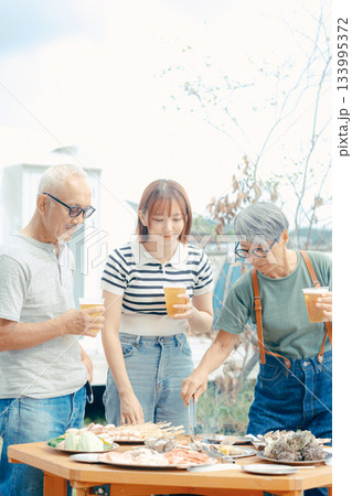 海辺で親子三人が立ち乾杯するシーン 133995372